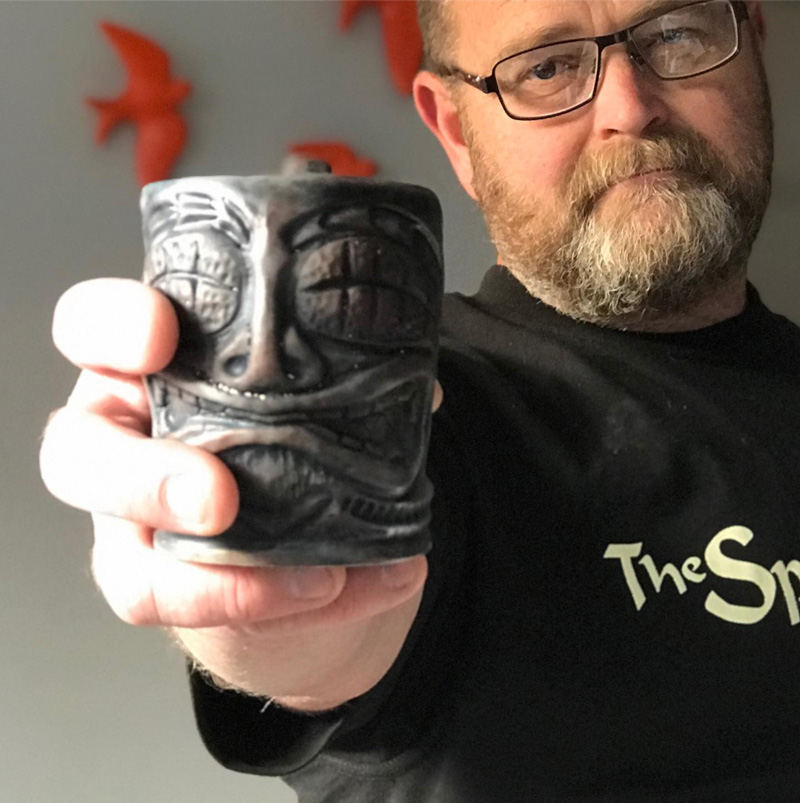 Andrew Cooke holding one of his tiki mugs