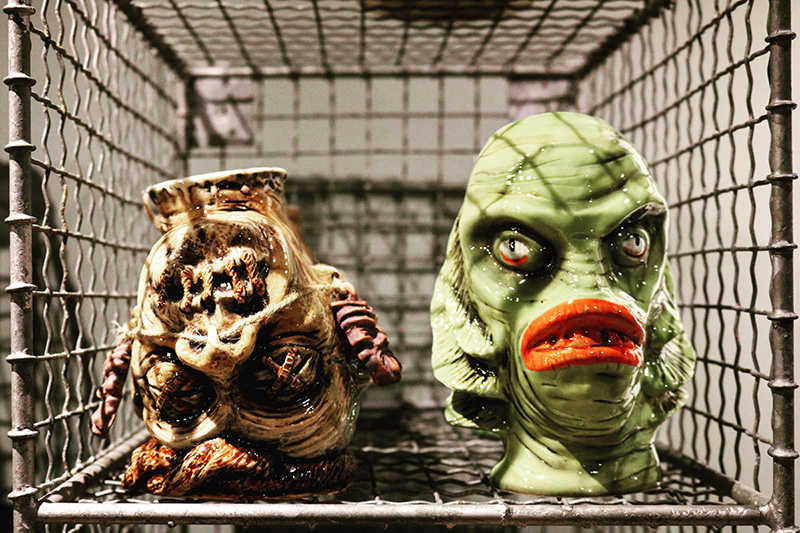 Shrunken head tiki mug and a Gilman mug